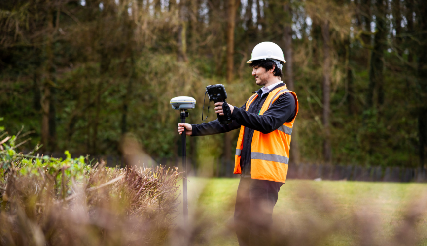 Egniol engineer in high vis vest and hard hat taking readings on technical equipment