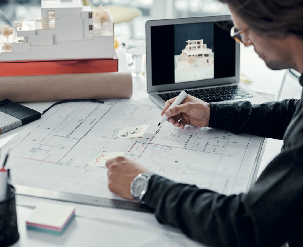 Designer working on plans and at a laptop - Principal Designer Building Safety Act